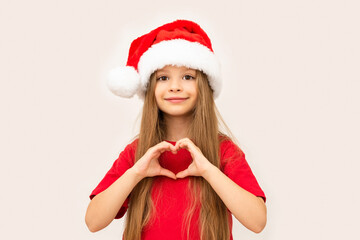 A little girl posing in a Christmas hat.