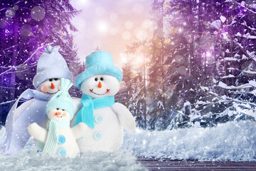 Cute toy snowman family with in winter forest. Space for text