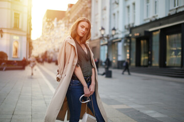 confident woman walking in autumn in the center of a big city. urban portrait of successful business woman