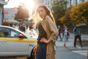 confident woman walking in autumn in the center of a big city. urban portrait of successful...