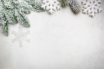 Christmas holidays composition with snowed fir tree branches and snowflakes on white background with copy space for your text