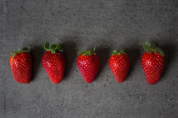 Fresh strawberries on dark grey table. Flat lay photo. Beautiful fruit texture close up. 