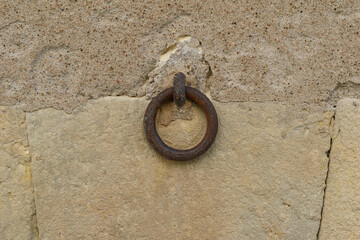 Vintage rusty iron  ring on old stone wall