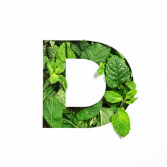 Letter D of English alphabet of green mint natural leafs and cut paper isolated on white. Leaves...