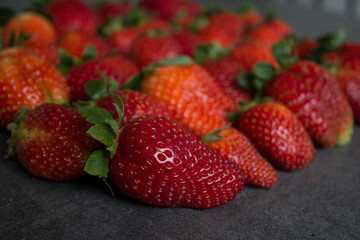 Fresh strawberries on dark grey table. Close up photo of juicy berries. Healthy eating concept. 