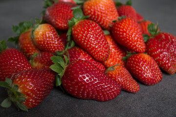 Fresh strawberries on dark grey table. Close up photo of juicy berries. Healthy eating concept. 