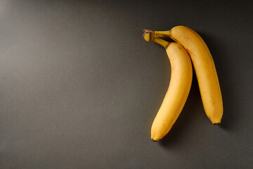 Yellow bananas on a dark background, top view