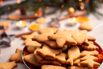 Cookies of different size and shapes in the bowl with some christmas decoration on the background