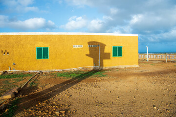 construcción con pared amarilla  y ventanas verdes  en la guajira 