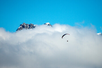Paragliding in the alps over the clouds