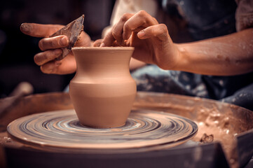 Creating a jar or vase. Master crock. Making clay jug. The sculptor in the workshop makes a jug out of earthenware closeup. Potter's wheel. Pottery concept.