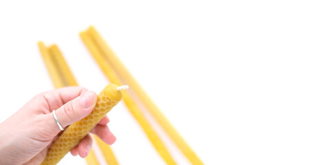 Hold a large wax candle in your hand. Banner isolated on white