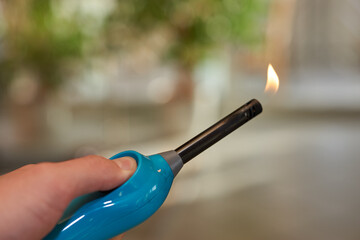 Aktiviertes Feuerzeug mit kleiner Flamme in Hand