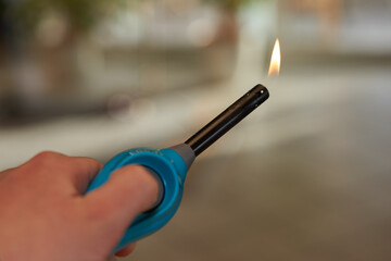 Aktiviertes Feuerzeug mit kleiner Flamme in Hand