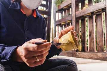 Girl with face mask painting a custom flowerpot with a brush