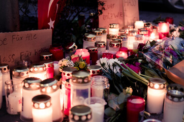 Hanau, Germany - February 20 2020: Flowers and Candles at the Hanau shooting site as a remembrance to the victims. Right extremism. Terror attack. - obrazy, fototapety, plakaty