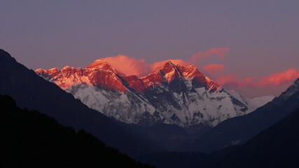 Stunning panorama view of mighty Mount Everest massif illuminated by the red colored evening light at sunset viewed from Sherpa village Namche Bazar in Sagarmatha National Park, Himalayas, Nepal.