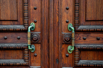 Fototapeta na wymiar Wooden carved beautiful doors with metal handles.