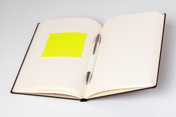 Carnet ouvert avec un stylo et une note autocollante