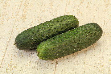 Green fresh cucumbers over background