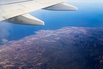 Fototapeta na wymiar Airplane wing over an island in the atlantic ocean