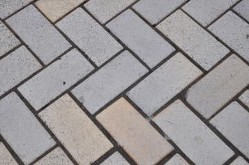 A close up of a paving herringbone pattern background as a common paver pattern for driveways.