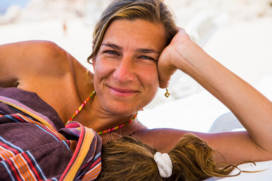 smiling woman resting with her young sleeping daughter,Cabo San Lucas,Mexico