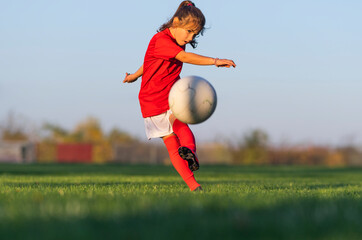 Little girl kicks soccer ball