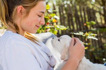 teen age girl holding a English golden retriever puppy