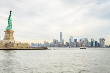Fototapeta premium Lady Liberty Statue with Lower Manhattan Futuristic Buildings and Towers in Background . New York City, USA