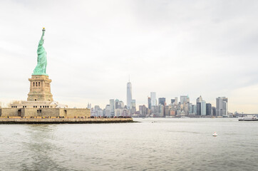Fototapeta premium Lady Liberty Statue with Lower Manhattan Futuristic Buildings and Towers in Background. New York City, USA