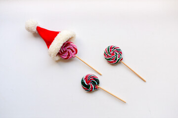 The candies on the white background.On the top of one candy is small Santa hat. High quality photo