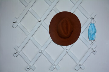 Cloakroom with a protective mask and a brown hat