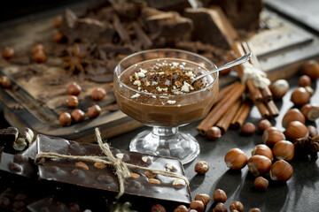 Dark chocolate in a composition with cocoa beans and nuts, on an old background.