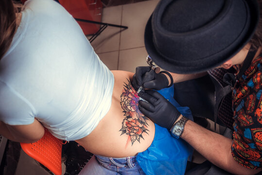 Master makes tattoo pictures in tattoo studio