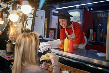 young caucasian employee in fast food service taking suggestions, listening, writing,  from a customer