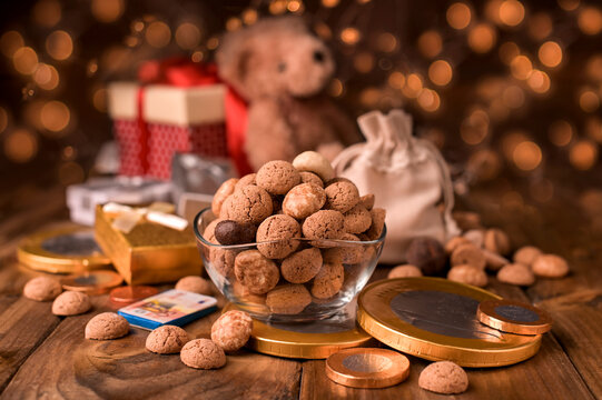 Dutch holiday Sinterklaas. kruidnoten cookies sweets, chocolate and a gift for the child. Children party Saint Nicholas day five december. Christmas bokeh and garlands on the background.