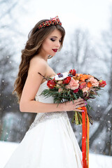 Young beautiful bride in a wedding dress with a bouquet of flowers.