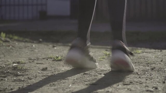 Close up of girl jumping rope in home environment on a sunny afternoon