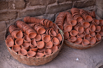 Traditional diya made of clay and mud placed in sunlight at Diya factory in Rural India. Diya used to lit home on the occasion of Diwali and other festivals.