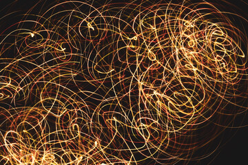 orange red and yellow laser lights intertwining on black background