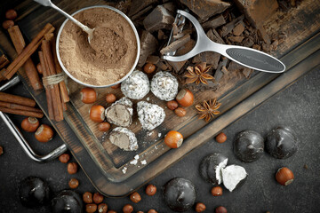 Dark chocolate in a composition with cocoa beans and nuts, on an old background.