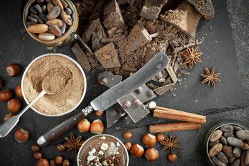 Pieces of dark chocolate and cocoa beans in composition on old background