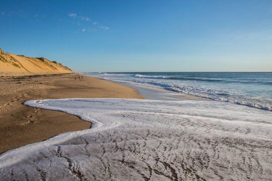 Close-up of seafoam waves lapping the beach sand at Whitecrest Beach