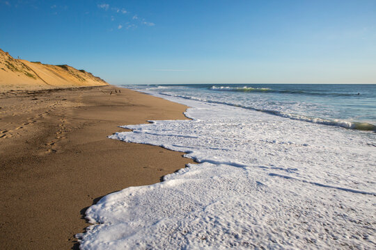 Close-up of seafoam waves lapping the beach sand at Whitecrest Beach