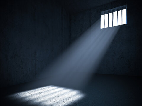 Interior of a prison with light from a barred window.