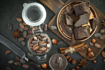 Hot chocolate on an old background in a composition with cocoa beans and nuts.