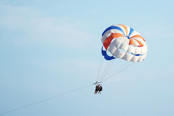  Parasailing. Parachute with passengers against the blue sky. The concept of the popular extreme - entertainment.