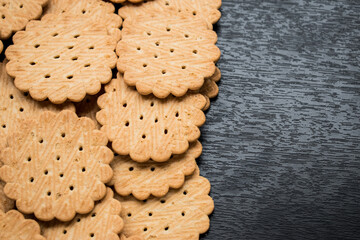 Close up of many little cookies on a black wooden table  