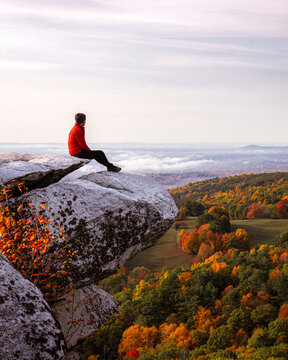person on the top of the mountain above the clouds during autumn